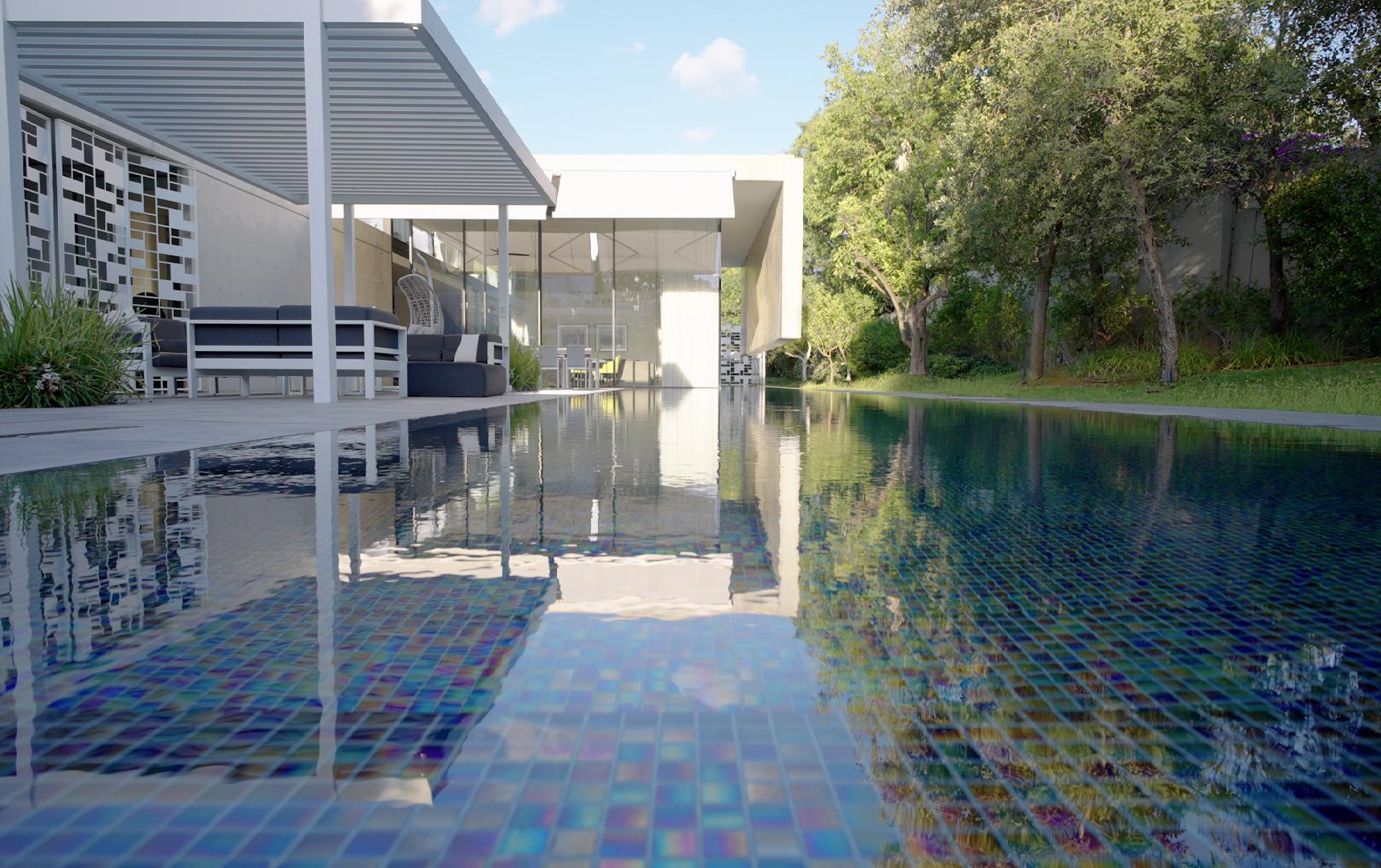 Pool level exterior view of a luxury residence featured in the Real Estate Promo